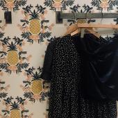 clothes hanging on a wall rack, pineapple wallpaper